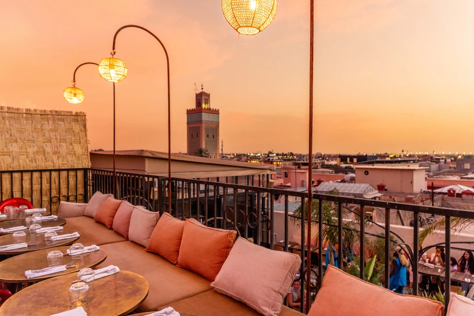 Lanterns and terrace seating overlooking the Koutoubia at sunset