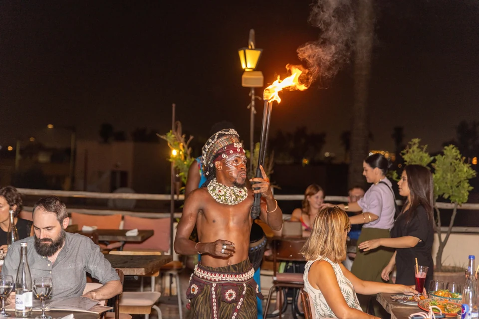 Fire performer presenting a live show beside restaurant tables at Coco Rooftop