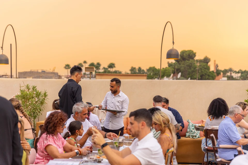 Restaurant team serving guests on the Coco Rooftop terrace